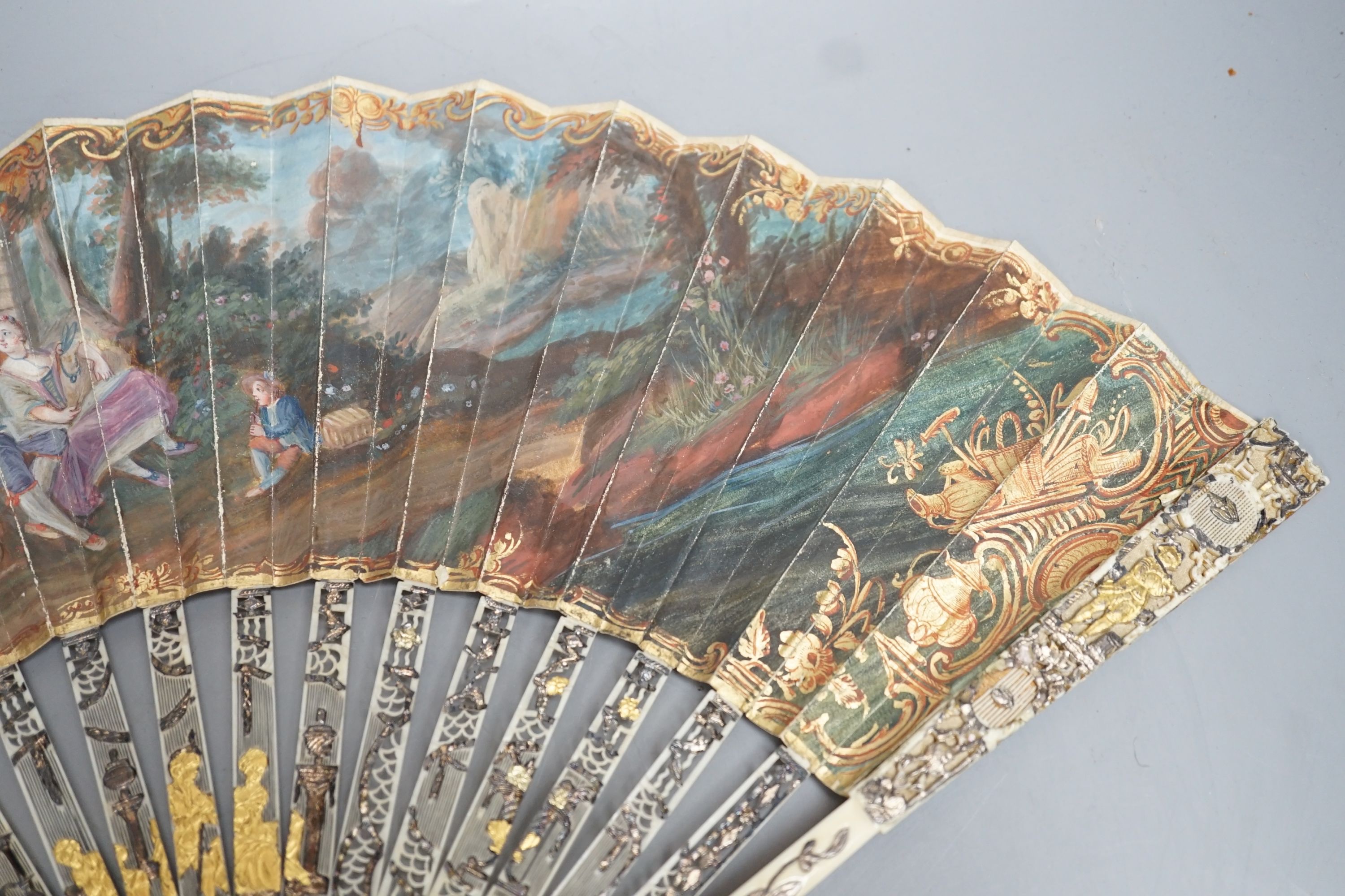 Two late 18th/early 19th century French gilded and silvered ivory and painted paper leaf fans